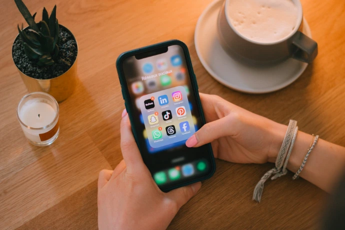 Woman uses a smartphone on a table.